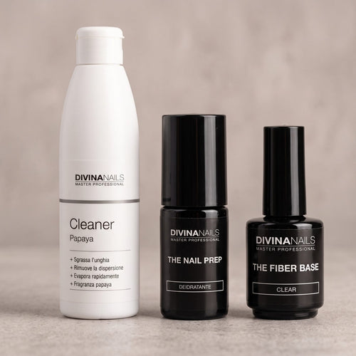THE CLEANER PAPAYA, THE NAIL PREP e THE FIBER BASE di DIVINA NAILS allineati su un piano di cemento: i prodotti della preparazione e della base per un semipermanente che dura 3 settimane